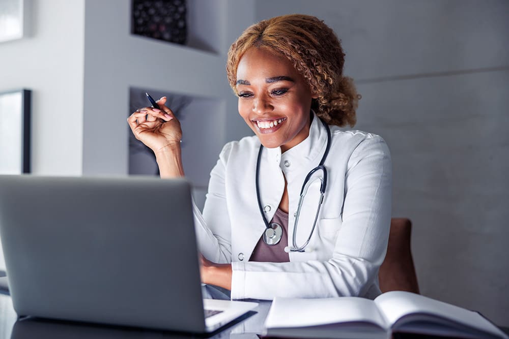 Doctor on her laptop reading an SEO for doctors article