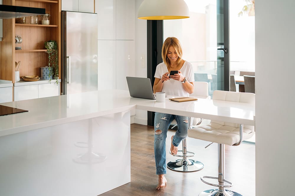 a woman sitting at a table with a laptop and a phone learning about SEO copywriting services